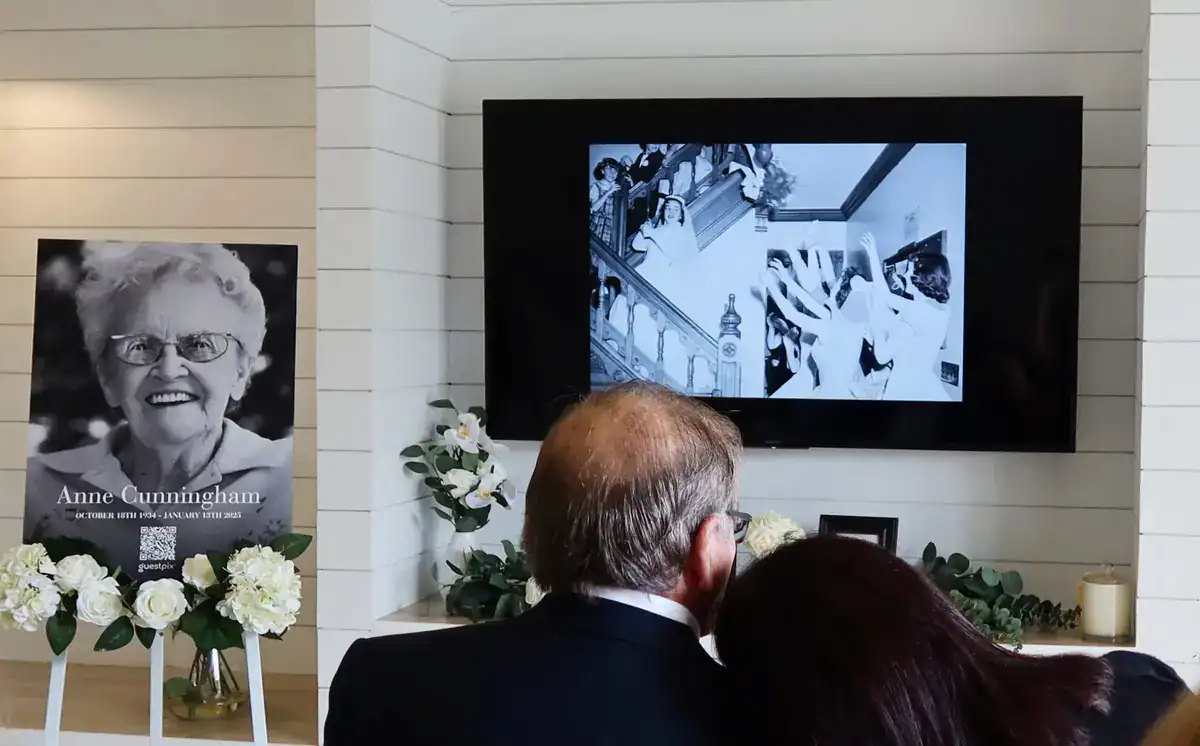 Memorial slideshow displayed on a screen at a funeral service.