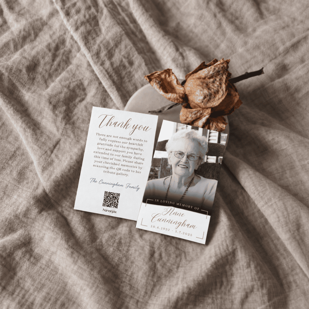 Memorial card with a photo of an elderly woman and a QR code on a beige fabric background.