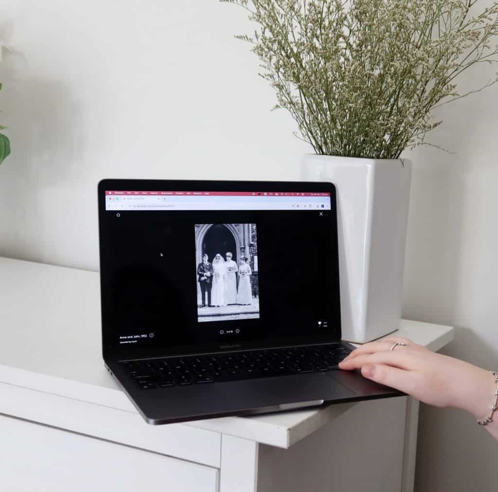 Person viewing a black and white memorial photo on a laptop screen.