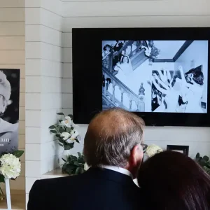 Memorial slideshow displayed on a screen at a funeral service.