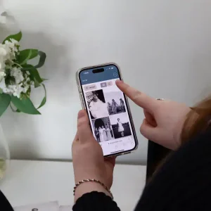 Person viewing memorial photos on a smartphone during a funeral service.